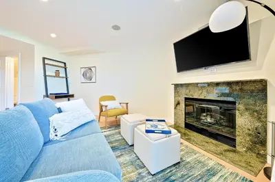 a living room with a blue couch and a fireplace at Sea & Sand Ocean Views in San Diego