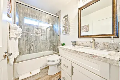 a bathroom with a toilet and a sink and a mirror at New Tremont Modern Beach in Oceanside