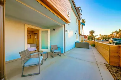 a porch with two chairs and a bed on a house at New Tremont Modern Beach in Oceanside
