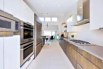 a kitchen with stainless steel appliances and a dining room at Seabluffe Ocean Spray in Encinitas