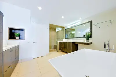 a bathroom with two sinks and a large mirror at Seabluffe Ocean Spray in Encinitas