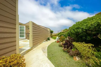 a backyard with a wooden fence next to a house at Seabluffe Ocean Spray in Encinitas
