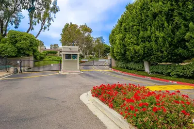a parking lot with a phone booth and red flowers at Seabluffe Ocean Spray in Encinitas