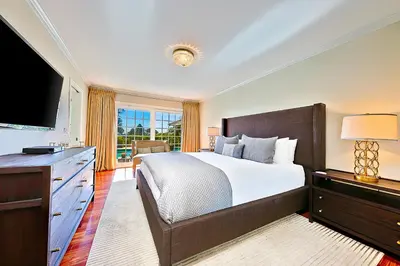 a bedroom with a large bed and a flat screen tv at La Jolla Scenic Retreat in San Diego