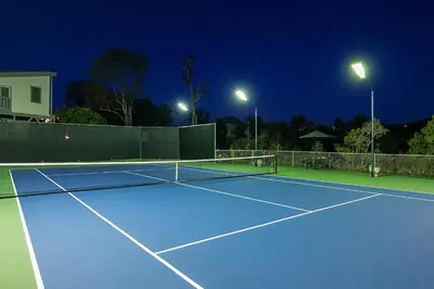 a tennis court is lit up at night at La Jolla Scenic Retreat in San Diego