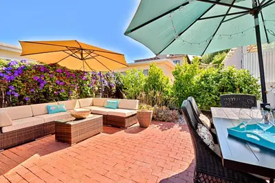 a patio with a couch and a table with an umbrella at Seashell Cottage in San Diego