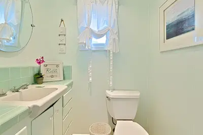 a white bathroom with a sink and a toilet at Seashell Cottage in San Diego