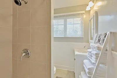 a bathroom with a shower and a sink and towels at Seashell Cottage in San Diego