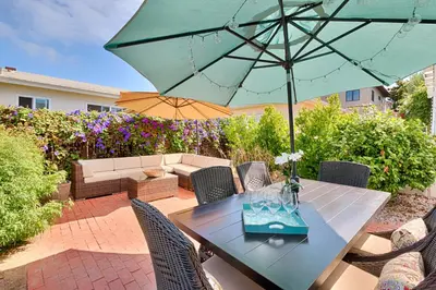 a patio with a table with an umbrella at Seashell Cottage in San Diego