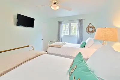 a bedroom with two beds and a flat screen tv at Seashell Cottage in San Diego