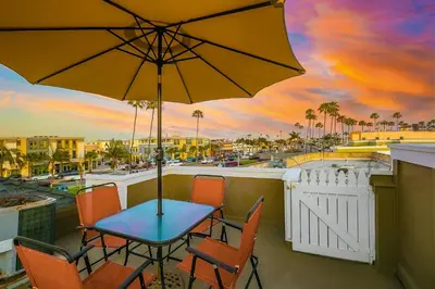 a table and chairs with an umbrella on a balcony at Great Balboa Peninsula Combo in Newport Beach