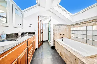 a bathroom with a tub and a sink and a mirror at Great Balboa Peninsula Combo in Newport Beach