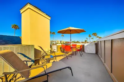 a patio with chairs and an umbrella on a building at Great Balboa Peninsula Combo in Newport Beach