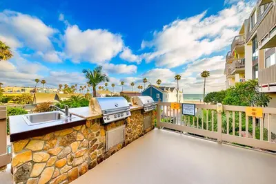 a balcony with a grill and a sink and a kitchen at Pier View Retreat in Oceanside