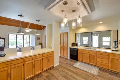 a large kitchen with wooden cabinets and a large island at Borrego Springs Getaway with Private Pool and Views! in Borrego Springs
