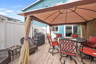 a patio with a table and chairs and an umbrella at Pacific Beach Cottage in San Diego