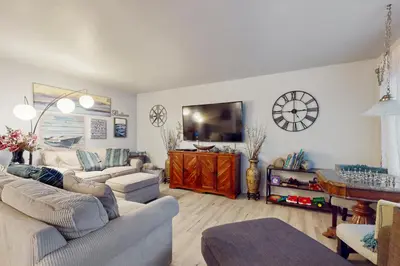 a living room with two couches and a flat screen tv at Pacific Beach Cottage in San Diego