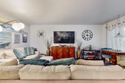 a living room with a couch and a tv at Pacific Beach Cottage in San Diego