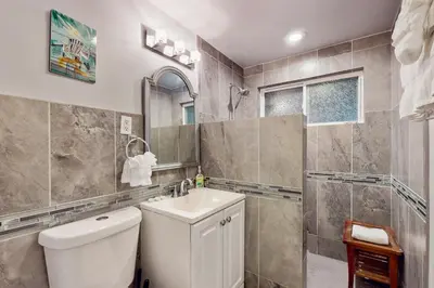 a bathroom with a toilet and a sink and a shower at Pacific Beach Cottage in San Diego