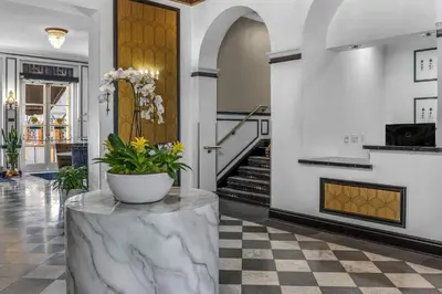a lobby with a marble table with a potted plant on it at Inn at the Park in San Diego