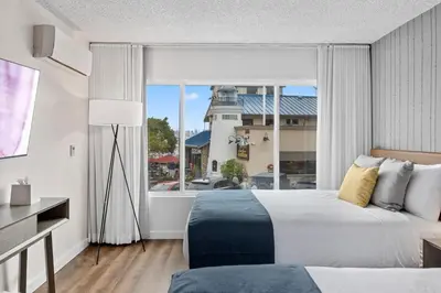 a hotel room with a bed and a window with a lighthouse at Sea Harbor Hotel - San Diego in San Diego