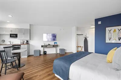 a bedroom with a large bed and a kitchen at Sea Harbor Hotel - San Diego in San Diego