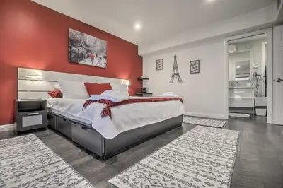 a bedroom with a large bed with a red wall at Contemporary San Diego Gem with Community Pool! in San Diego