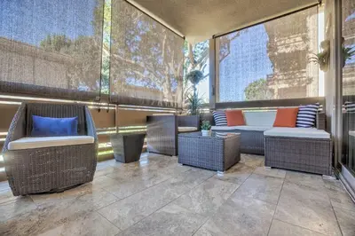 a balcony with wicker chairs and a table and a couch at Contemporary San Diego Gem with Community Pool! in San Diego