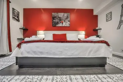 a bedroom with a large bed with a red wall at Contemporary San Diego Gem with Community Pool! in San Diego