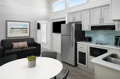 a kitchen with a table and a refrigerator at Sun Outdoors San Diego Bay in Chula Vista