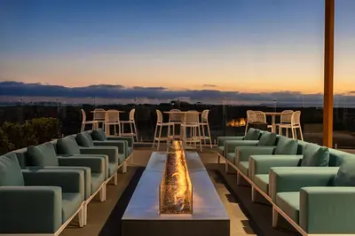 a row of chairs and a table on a roof at Sun Outdoors San Diego Bay in Chula Vista