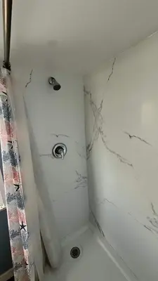 a bathroom with a shower with white marble walls at Big Studio with Ocean View max 6 sleepers in San Diego