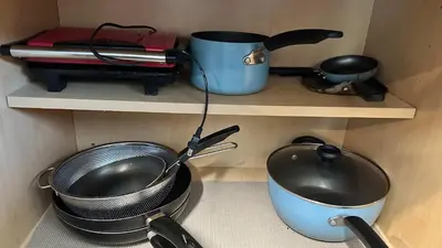 a shelf with some pots and pans and a pot and a pan at Big Studio with Ocean View max 6 sleepers in San Diego