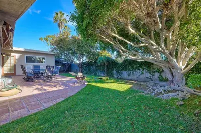 a backyard with a tree and a brick patio at Great Group Retreat! Hacienda Decor, Spacious Floor Plan, Private Backyard in Carlsbad