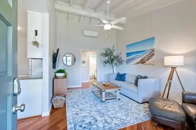 a living room with a blue couch and a table at 90 Walk Score - Steps to Beach & Dining - Reserved Parking in Carlsbad