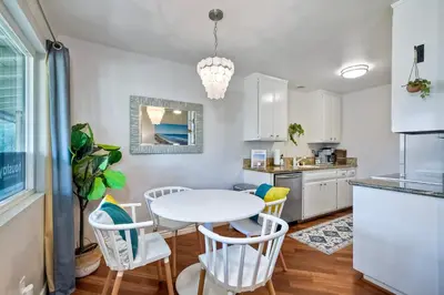 a kitchen and dining room with a table and chairs at 90 Walk Score - Steps to Beach & Dining - Reserved Parking in Carlsbad