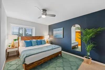 a bedroom with a bed with blue walls and a mirror at 4 BR Home with Game Room! Family Friendly! Centrally Located! in San Diego