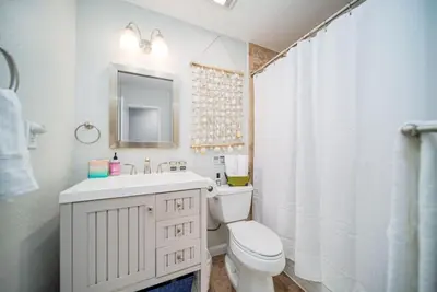 a white bathroom with a toilet and a sink at 4 BR Home with Game Room! Family Friendly! Centrally Located! in San Diego