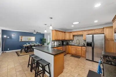 a kitchen with wooden cabinets and a stainless steel refrigerator at 4 BR Home with Game Room! Family Friendly! Centrally Located! in San Diego