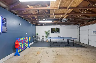 a room with a ping pong table and chairs at 4 BR Home with Game Room! Family Friendly! Centrally Located! in San Diego
