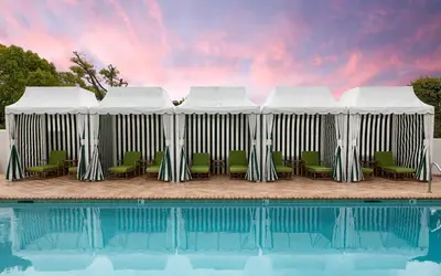 a pool with chairs and a pavilion next to at The Inn at Rancho Santa Fe in Rancho Santa Fe