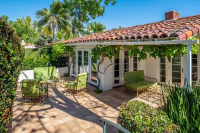 a patio with green chairs and a house at The Inn at Rancho Santa Fe in Rancho Santa Fe