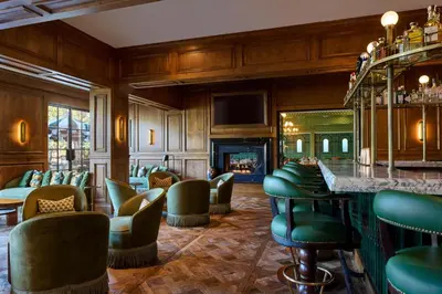 a bar with green chairs and a fireplace at The Inn at Rancho Santa Fe in Rancho Santa Fe