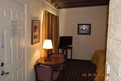 a hotel room with a bed and a table with a lamp at Stanlunds Inn and Suites in Borrego Springs