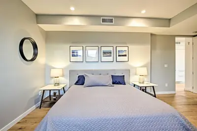 a bedroom with a large bed and two tables with lamps at Chic Coronado Retreat with Patio and 4 Cruiser Bikes! in San Diego