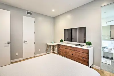a bedroom with a large flat screen tv on a wall at Chic Coronado Retreat with Patio and 4 Cruiser Bikes! in San Diego