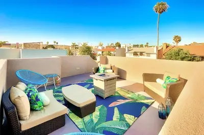 a patio with chairs and tables on a balcony at Crown Point Views Home in San Diego