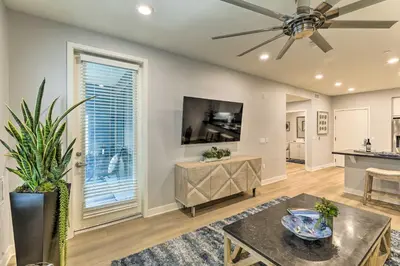 a living room with a ceiling fan and a table at Modern Irvine Condo with Pool - 7 Mi to Beach! in Irvine