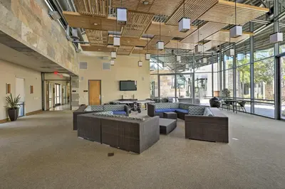 a large room with couches and tables and windows at Modern Irvine Condo with Pool - 7 Mi to Beach! in Irvine