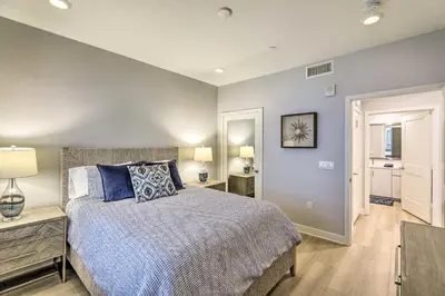 a bedroom with a bed with blue pillows at Modern Irvine Condo with Pool - 7 Mi to Beach! in Irvine